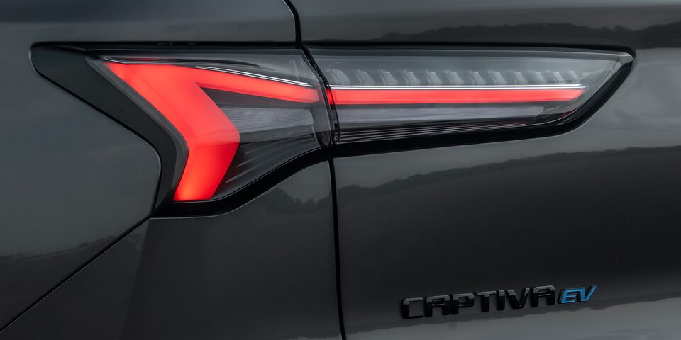Vista en detalle de las luces traseras LED encendidas de la Chevrolet Captiva EV, con el emblema Captiva EV debajo.