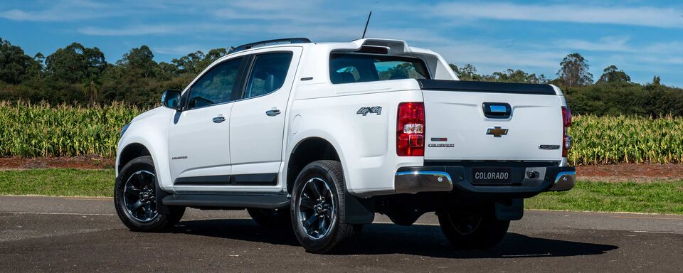 Vista lateral trasero en ambiente rural de la camioneta Chevrolet Colorado High Country