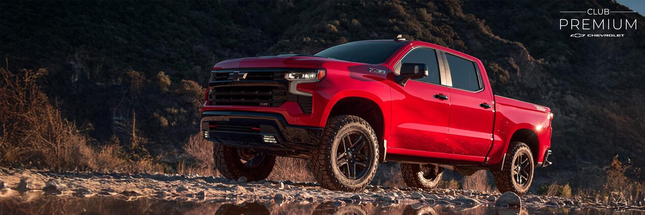 Chevrolet Silverado Z71 estacionada en una zona montañosa, mientras se refleja en un charco de agua.