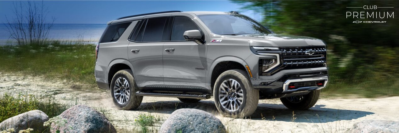 Chevrolet Tahoe circulando por camino de arena, con vegetación y el mar de fondo.