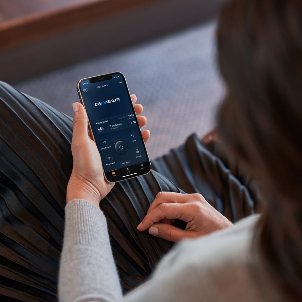 Una mujer utilizando la app MyChevrolet mientras esrá sentada.