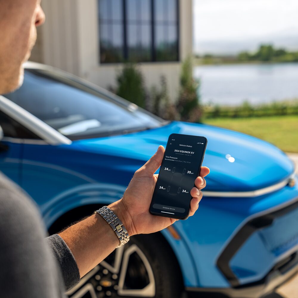 Un hombre utilizando la app MyChevrolet antes de subir a su vehículo Chevrolet.
