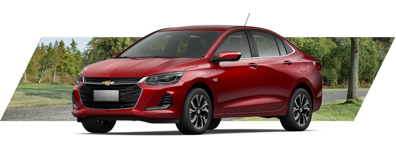 Chevrolet sedán Onix color rojo, elegante diseño exterior en paisaje natural, ideal para viajes familiares