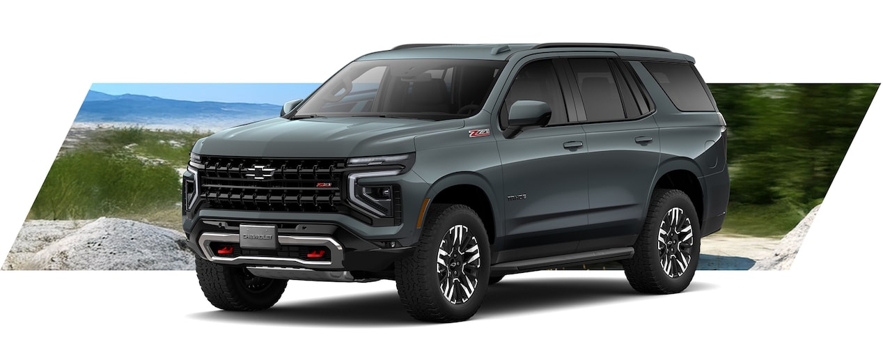 Chevrolet Tahoe Z71 en color gris oscuro sobre terreno off-road, SUV robusta ideal para aventuras y caminos exigentes