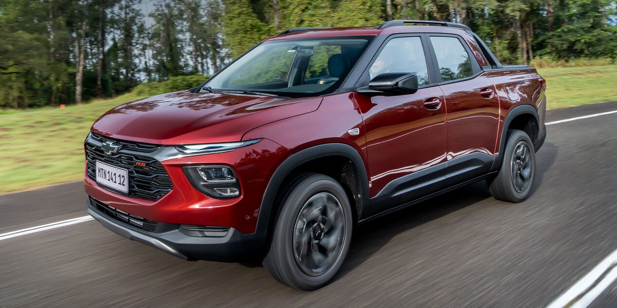 Imagen de una Chevrolet Montana circulando en carretera, con árboles al fondo.