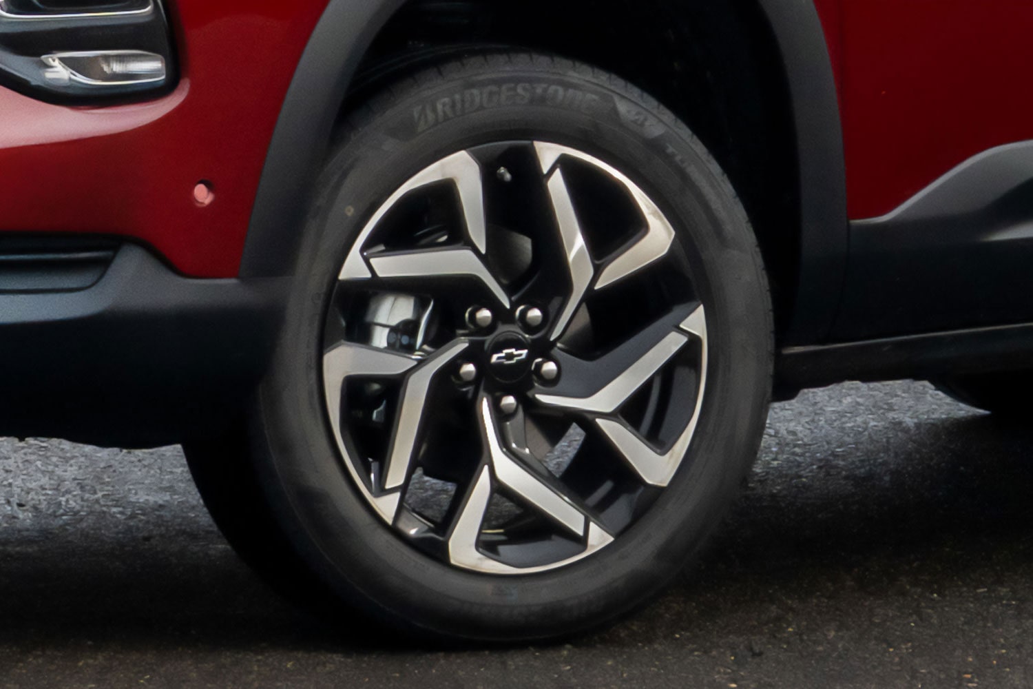 Vista en detalle de la rueda delantera izquierda de la Chevrolet Montana, destacando llantas de aleación bitono.