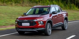 Imagen de una Chevrolet Montana circulando en carretera, con árboles al fondo. 