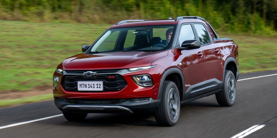 Imagen de una Chevrolet Montana circulando en carretera, con árboles al fondo.