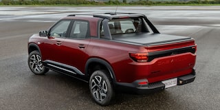 Imagen de una Chevrolet Montana estacionada en una zona descampada al aire libre vista desde atrás y en ángulo.