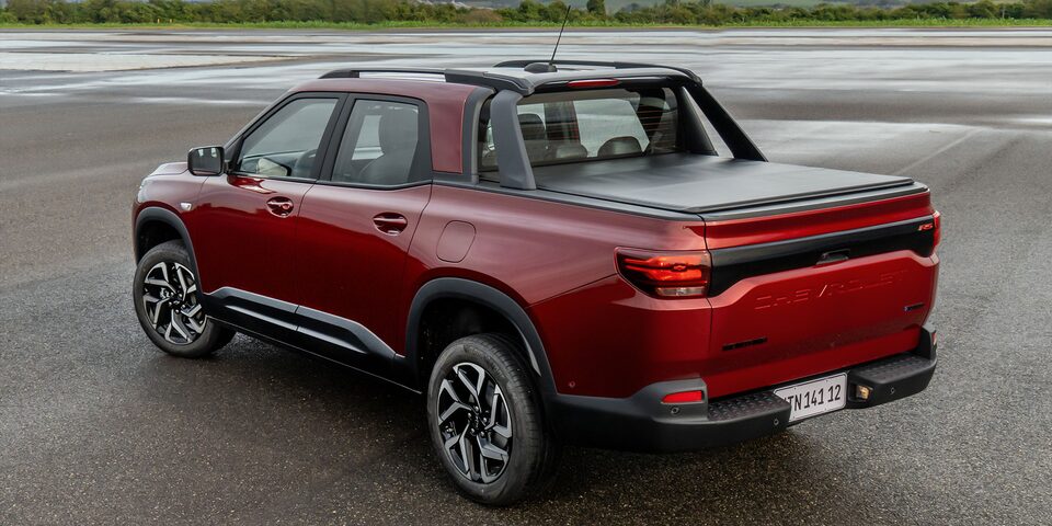 Imagen de una Chevrolet Montana estacionada en una zona descampada al aire libre vista desde atrás y en ángulo.