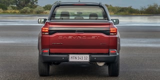 Imagen de una Chevrolet Montana estacionada en una zona descampada al aire libre vista desde atrás.