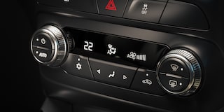 Panel de control del climatizador en el interior de una Chevrolet Montana, con perillas cromadas, pantalla digital central que marca 22 grados y botones para ajustar ventilación, temperatura y modo de circulación de aire.