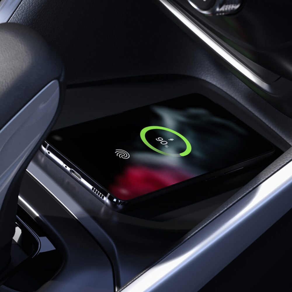 Base de carga inalámbrica en la consola central de una Chevrolet Montana, con un teléfono apoyado que muestra el indicador de batería cargándose junto a la palanca de cambios.