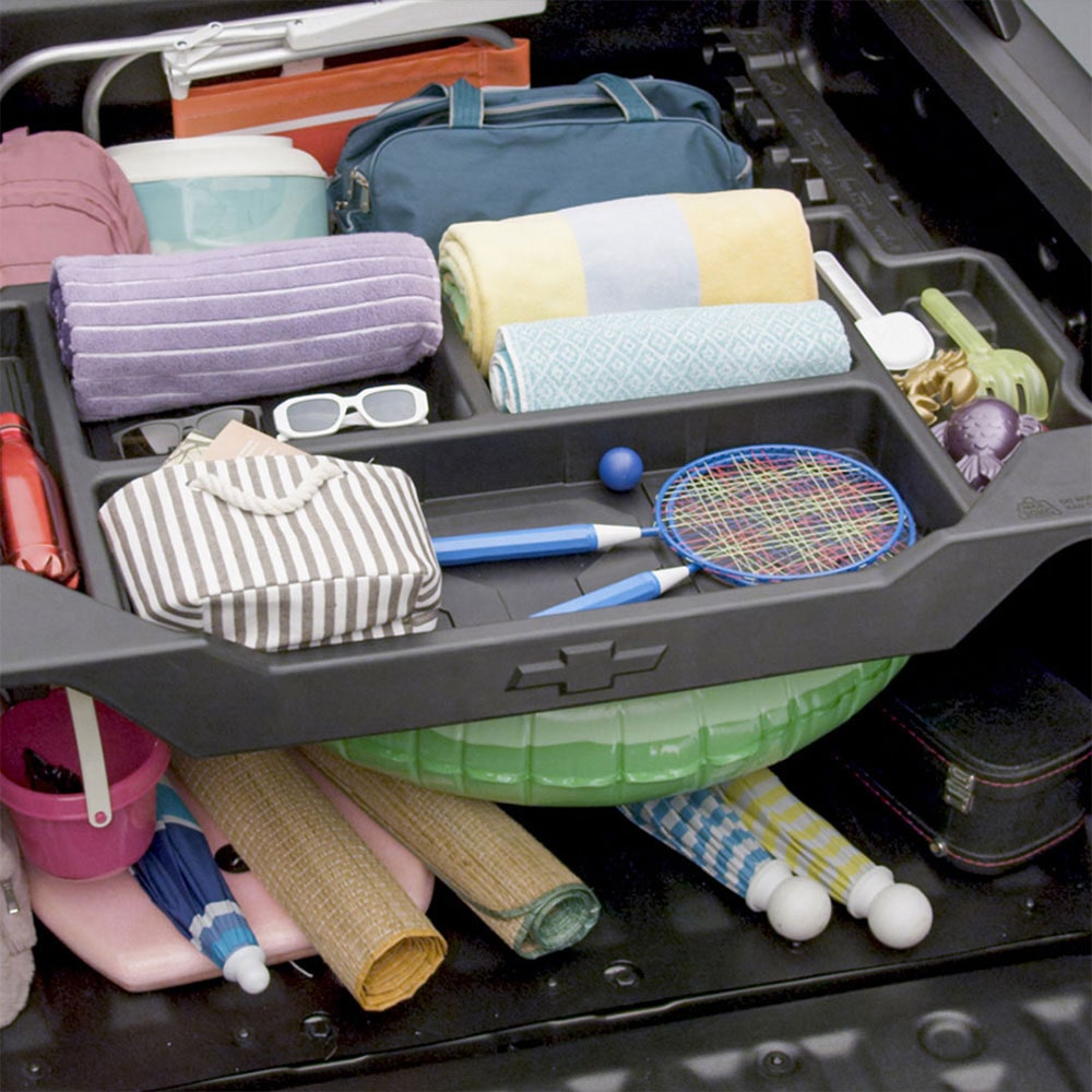 Imagen de la caja Multi-Flex de una Chevrolet Montana repleta de objetos: sombrillas, lentes de sol, lonas de playa, reposeras, raquetas, y más.