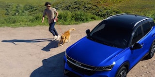 Chevrolet Groove estacionada con un hombre y un perro caminando cerca.