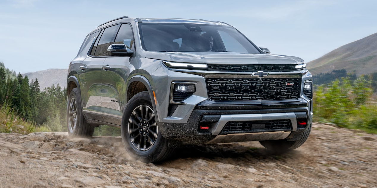 Vista frontal Chevrolet Traverse andando en camino de piedra.